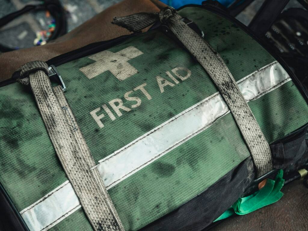 Green and black first-aid bag packed with basic supplies