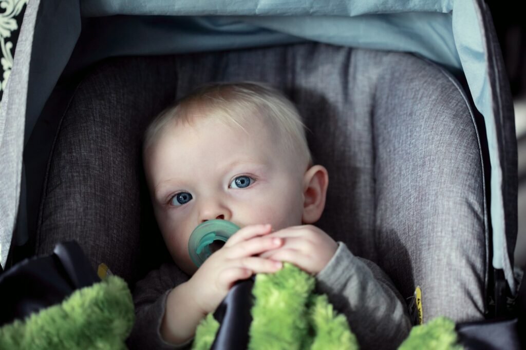 Baby secured in a properly fitted car seat, illustrating a harness and buckle check