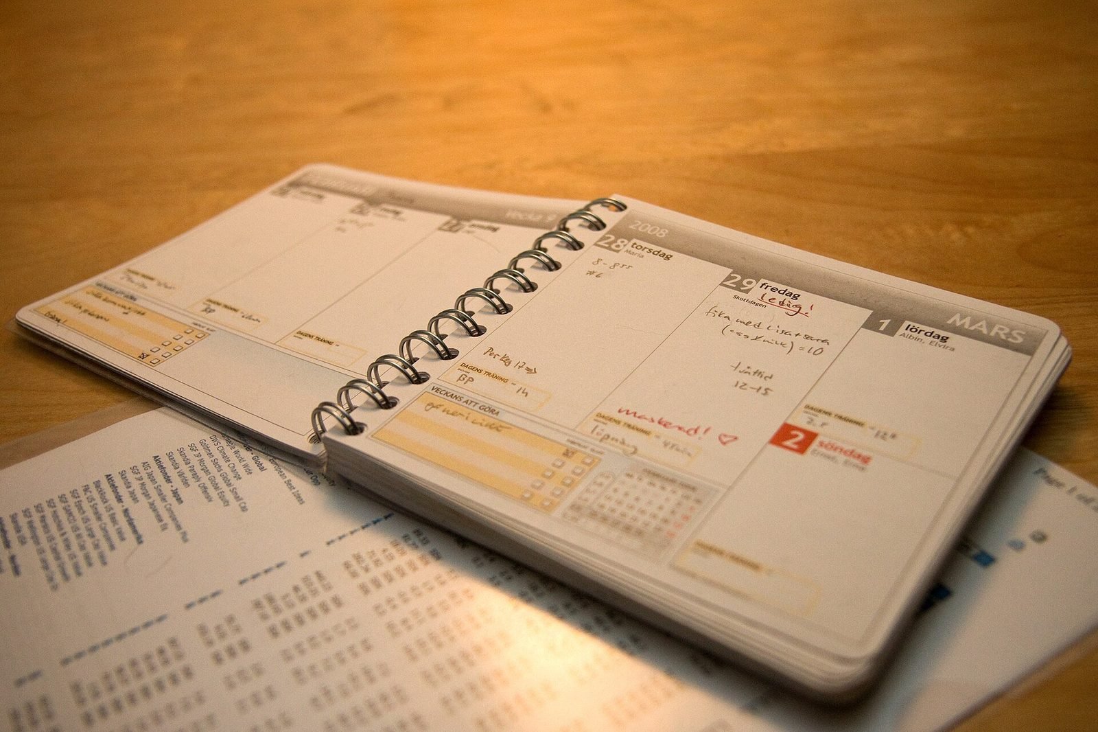 Open weekly planner with handwritten notes on a wooden table