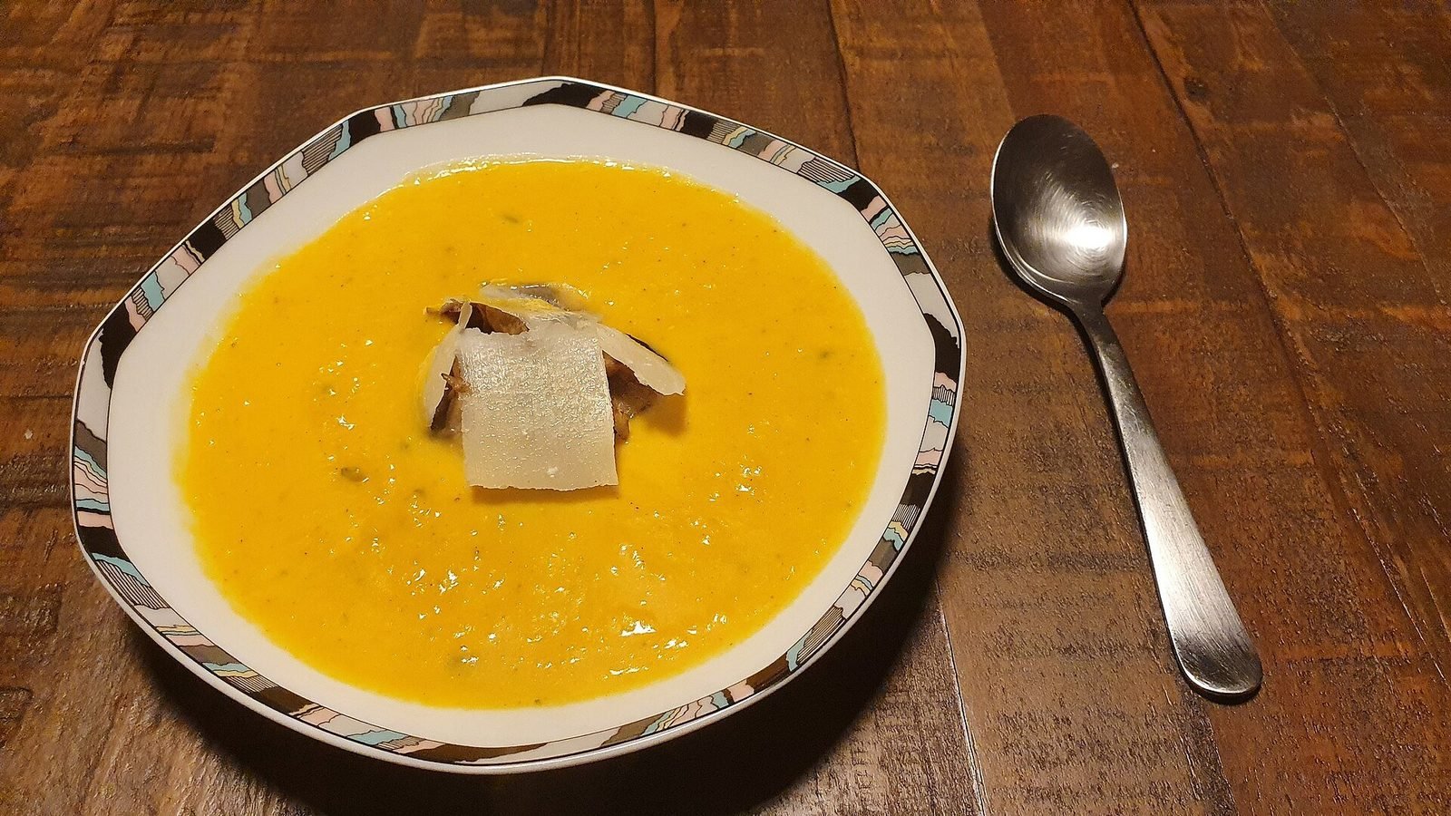 Bowl of pumpkin soup with a spoon