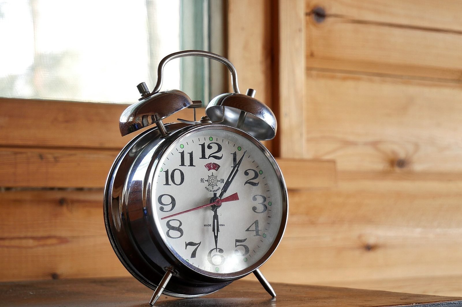 Classic twin-bell alarm clock on a wooden table